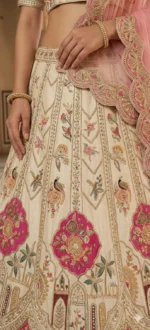 Close-up view of ivory lehenga with blush pink embroidery and zari detailing