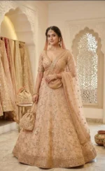 Close-up of champagne gold lehenga with intricate threadwork and sequin embroidery