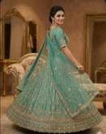 Back view of designer emerald green lehenga with intricate zari embroidery and net dupatta