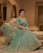 Woman wearing emerald green embroidered lehenga set with zari work and soft net dupatta